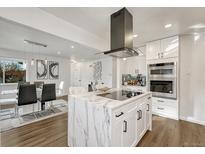 Modern white kitchen featuring a marble island, stainless steel appliances, and stylish black accents at 3550 Eudora St, Denver, CO 80207
