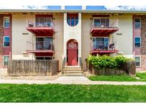 Charming condo building featuring balconies with red trim and well-maintained landscaping at 12132 Huron St # 203, Denver, CO 80234