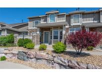Beautiful townhome with a stone exterior, landscaping, and a well-maintained front yard at 4887 Raven Run, Broomfield, CO 80023