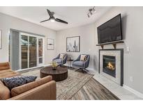 Bright living room with fireplace, hardwood floors, and sliding glass door to patio at 8757 E Dry Creek Rd # 1512, Englewood, CO 80112