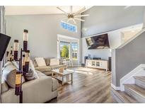 Bright living room with high ceilings, modern flooring, large windows, and a comfortable seating area at 16160 E 119Th Ave, Commerce City, CO 80022