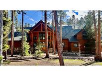 Charming wood cabin home with stone accents and lush forest landscaping in a private, serene setting at 47 Forest Cir, Breckenridge, CO 80424