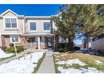 Beige townhouse exterior with brick accents, a small front yard, and walkway at 1214 S Zeno Way # D, Aurora, CO 80017