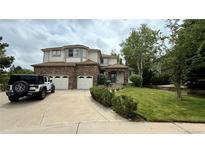 Charming two-story home with brick accents, a three-car garage, and a well-manicured front yard at 7858 Oban Ct, Lone Tree, CO 80124