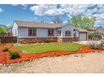 Charming single story home with stone accents, tidy landscaping, and vibrant mulch beds at 1035 Quartz St, Golden, CO 80401