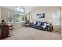 Bright living room featuring a vaulted ceiling, large windows, and comfortable seating, perfect for relaxation and entertaining at 6534 S Union Way, Littleton, CO 80127
