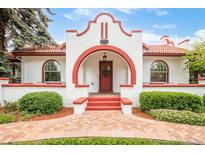 Charming front entrance with red brick accents, a red front door and manicured landscaping at 2715 W 37Th Ave, Denver, CO 80211