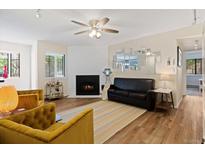 Cozy living room featuring a fireplace, unique mirror decor, and stylish furniture at 534 E 7Th Ave # 101, Denver, CO 80203