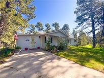 Charming single-story home featuring a well-manicured lawn and mature trees offering shade and privacy at 5777 County Road 154, Elizabeth, CO 80107