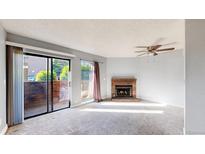 Bright living room with sliding glass doors and a cozy brick fireplace at 12360 W Nevada Pl # 101, Lakewood, CO 80228