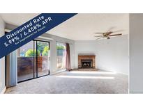 Bright living room featuring a fireplace and sliding glass door to a private patio at 12360 W Nevada Pl # 101, Lakewood, CO 80228