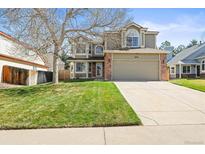 Charming two-story home with a well-manicured lawn, mature tree, and spacious driveway at 11636 Laurel Ln, Parker, CO 80138