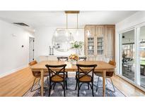 Elegant dining space with hardwood floors, chic lighting, and a seamless transition to outdoor entertaining at 3560 S Glencoe St, Denver, CO 80237