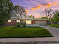 Charming brick ranch home with a well-manicured lawn and a long driveway leading to an attached garage at 3560 S Glencoe St, Denver, CO 80237
