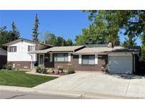 Charming brick home with a well-maintained front yard, driveway, and attached garage at 1299 S Brentwood Way, Lakewood, CO 80232