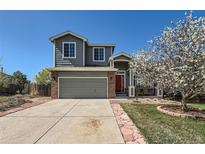 Charming two-story home featuring a front porch, red front door, and a manicured lawn at 21684 Swale Ave, Parker, CO 80138