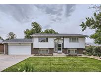 Charming two-story home features a well-manicured front lawn and an attached garage at 845 S 9Th Ave, Brighton, CO 80601