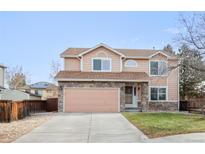 Two-story house with a peach facade, stone accents, and a two-car garage at 19360 E 45Th Ave, Denver, CO 80249