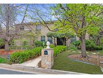 Charming two-story brick home with a lush, landscaped front yard and a stone mailbox at 4070 S Hudson Way, Englewood, CO 80113