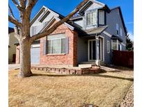 Charming two-story home with blue siding, brick accents, and a well-manicured front yard at 1022 Morning Dove Dr, Longmont, CO 80504