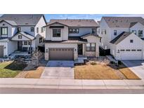 Charming two-story home boasts a well-manicured lawn and a two-car garage, showcasing curb appeal at 11220 Bellsong Ln, Littleton, CO 80125
