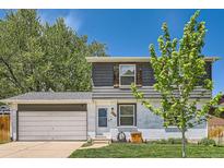 Charming home with a gray and white exterior, a well-kept lawn, and a spacious two-car garage at 10541 Routt St, Westminster, CO 80021