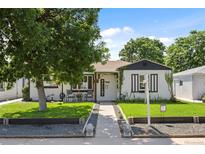 Charming home with a well-manicured front yard and welcoming entrance, featuring a mature shade tree at 4389 S Sherman St, Englewood, CO 80113