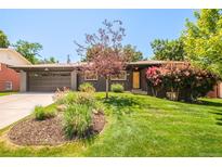 Charming single-story home featuring a landscaped front yard and an attached two-car garage at 621 S Harrison Ln, Denver, CO 80209