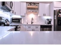 Modern kitchen featuring stainless steel appliances and beautiful backsplash design at 650 S Clinton St # 2A, Denver, CO 80247
