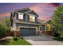 Charming two-story home featuring a two-car garage, brick accents, and professional landscaping at 10647 Nucla St, Commerce City, CO 80022
