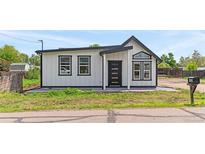 Charming home featuring modern design with vertical siding and black trim windows at 1100 Urban St, Lakewood, CO 80401