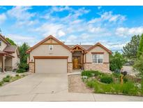 Charming single-Gathering home featuring a two-car garage, manicured landscaping and a lovely stone accent at 2807 S Nelson St, Lakewood, CO 80227