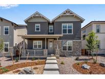 Charming two-story home with gray siding, stone accents, and a cozy front porch at 24851 E 33Rd Dr, Aurora, CO 80019