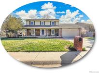 Traditional two-story home with a brick facade, covered porch, and well-manicured lawn at 3790 E Geddes Ave, Centennial, CO 80122