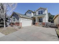 Charming two-story home featuring a well-manicured lawn, attached garage, and inviting front porch at 2608 S Troy Ct, Aurora, CO 80014