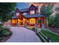 Charming two-story home with inviting front porch, lush landscaping and circular driveway at 1300 W Caley Ave, Littleton, CO 80120