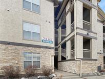 Condominium exterior showcasing stone accents, neutral stucco, and stairs to upper levels at 7483 S Quail Cir # 635, Littleton, CO 80127