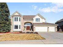 Charming two-story home features a three-car garage, well-manicured lawn and beautiful brick and siding at 9556 Kemper Dr, Lone Tree, CO 80124