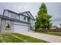 Charming two-story home with a well-manicured lawn, gray siding, brick accents, and an attached two-car garage at 475 Hampstead Ave, Castle Rock, CO 80104