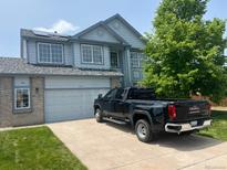 Two-story home featuring a gray two-car garage, blue siding, and solar panels on the roof at 475 Hampstead Ave, Castle Rock, CO 80104