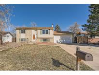 Split-level home with a brick and vinyl facade, attached two car garage and a lawn with a mailbox at 16147 E Bethany Pl, Aurora, CO 80013