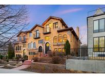 Elegant, multi-story home boasting stucco siding, stone accents, and private balconies at 566 Monroe St, Denver, CO 80206