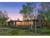 Charming single-story home featuring large windows, a brick chimney, and lovely landscaping, perfect for modern living at 8955 E 19Th Ave, Aurora, CO 80010