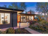 Charming single-story home with a red door, large windows, and a beautifully landscaped front yard at 8955 E 19Th Ave, Aurora, CO 80010