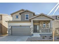 Charming two-story home with stone accents, covered porch, and two car garage at 728 N Clubview St, Watkins, CO 80137