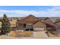 Charming two-story home with a well-maintained lawn and attached two-car garage and covered porch at 21753 E Heritage Pkwy, Aurora, CO 80016