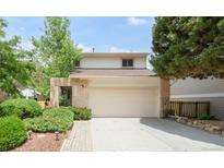 Charming two-story home with a well-manicured lawn, mature trees, and a two car garage at 4034 S Atchison Way, Aurora, CO 80014