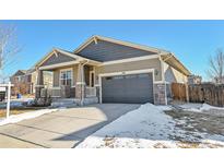 Tan two-story house with gray roof, stone accents, and a two-car garage at 398 Beldock St, Brighton, CO 80601