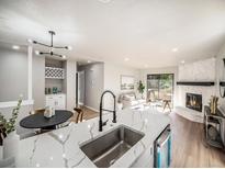 Modern kitchen with white cabinets, quartz countertops, and stainless steel appliances at 7870 W 87Th Dr # L, Arvada, CO 80005