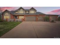 Charming two-story home with a three-car garage, brick facade, and a neatly manicured lawn at 19770 E Geddes Pl, Centennial, CO 80016